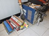 a pile of books on the floor next to a blue box