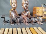two wooden figurines of two men sitting on a bench