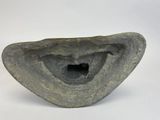 a stone sculpture with a hole in it on a white surface