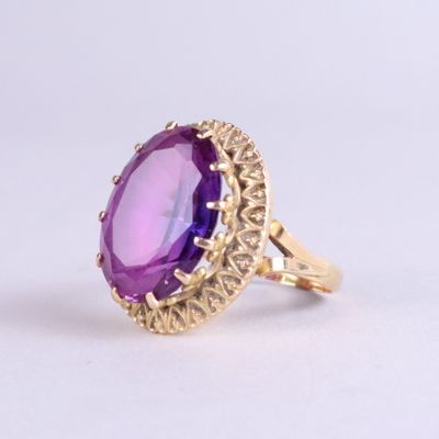 an image of a gold ring with a purple stone in the center