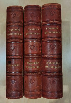four old leather books sitting on top of a wooden table