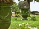 deux grands vases verts posés au milieu d'un jardin