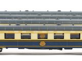 several blue and yellow train cars are lined up on a white surface