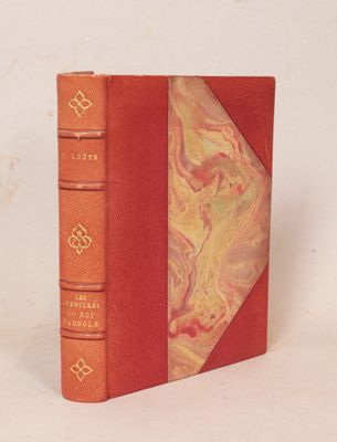 un livre rouge à la couverture marbrée sur fond blanc