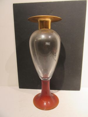 a glass vase with a gold top sitting on a table