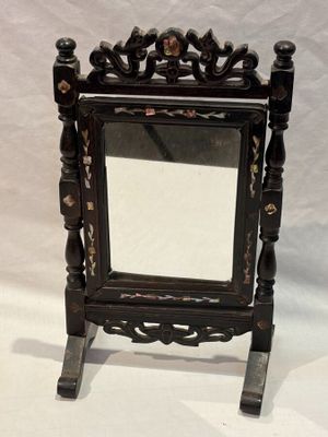 a mirror that is sitting on a stand on a white background