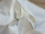 a bed with a white sheet on it and a wooden headboard