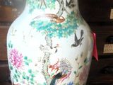 a vase that is sitting on a table with a lamp on it