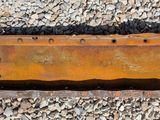 a close up of a rusted piece of metal on a gravel ground
