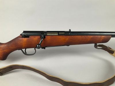 a rifle with a wooden barrel and a leather strap
