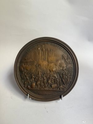 une plaque antique en bronze représentant la bataille de Waterloo sur fond blanc