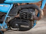a blue motorcycle parked in front of a brick wall