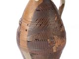 un vase marron et blanc muni d'une anse, sur fond blanc