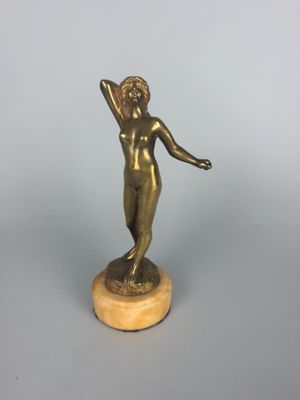 bronze statue of a woman holding a ball on a marble base
