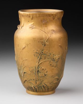 un vase en or orné d'un motif représentant des fleurs et des oiseaux
