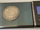 a silver coin sitting on top of an electronic scale