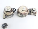 three different pieces of pottery sitting on a white surface