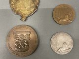 several different coins are displayed in a display case on a table