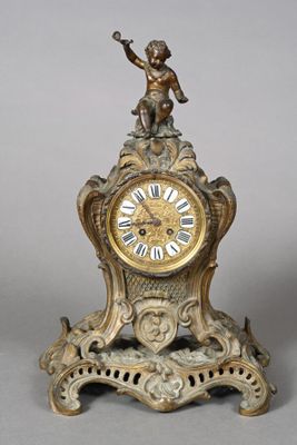 a gold clock with a little boy on top of it