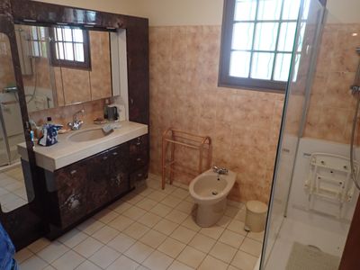 une salle de bains équipée de toilettes, d'un lavabo et d'une douche