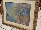 tableau représentant un arbre dans un cadre doré, posé sur un sol carrelé