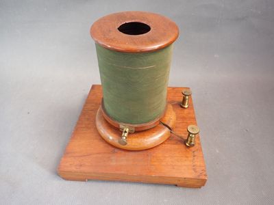 une bobine de fil posée sur un support en bois