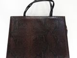 un sac à main en peau de serpent marron sur fond blanc