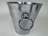 a silver vase with a ring in it on a table