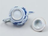 a blue and white tea pot and a white cup