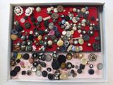 many buttons in a box on a red surface