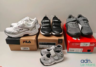 Plusieurs paires de chaussures sont posées sur des cartons, sur une table.