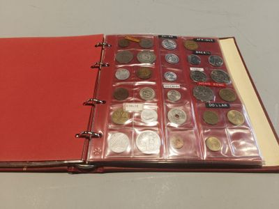 a red book with a bunch of coins inside of it