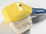 a small yellow and blue brush with a tag on it