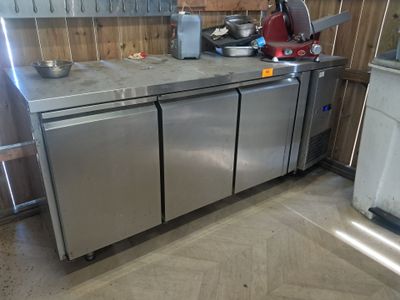 une cuisine équipée d'appareils électroménagers en inox et d'un évier