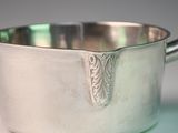 a silver sauce pot with a spoon in it
