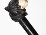 a black bear head on top of a black cane