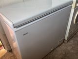 un petit réfrigérateur blanc à côté d'un sèche-linge et d'un sèche-linge