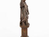 a wooden statue of a woman holding a child on a pedestal