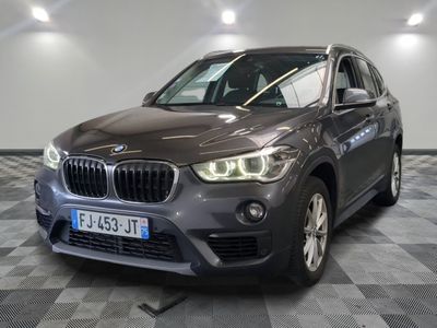 La BMW X1 est garée dans un showroom dont le sol est en damier.