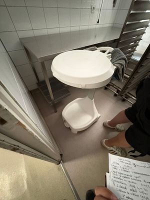 a person standing in a kitchen with a paper