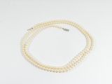 gros plan d'un collier de perles blanches sur une surface blanche