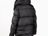 the back view of a black down jacket on a mannequin stand