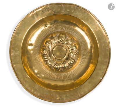une assiette en or ornée d'un motif sur fond blanc