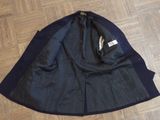 jacket on the floor on a wooden floor with a tag on it