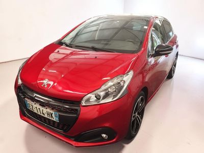 La voiture rouge est garée dans la salle blanche du showroom.