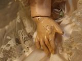 a close up of a doll wearing a white dress