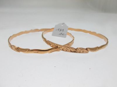 deux bracelets en or présentant des motifs gravés sur un fond blanc