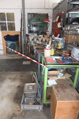 a garage with a lot of clutter and tools on the floor