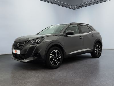 Le SUV gris est garé dans une grande pièce aux murs blancs.