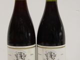 pair of two bottles of wine sitting on a white surface